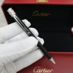قلم سانتوس دي كارتير مع الملحقات - قلم Santos de Cartier أسود بتفاصيل ذهبية، موديل نحيف وحبر جاف عملي، مناسب للتوقيع والهدايا المكتبية. اطلبه الآن.