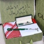 بوكس هدية عيد ميلاد للزوج يحتوي على شماغ وقماش ثوب أبيض وسبحة خضراء وقلم فاخر مع ورود وتغليف أنيق